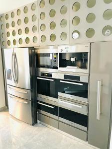 奎斯特邦多拉Luxurious house in peaceful natural surroundings的厨房配有不锈钢冰箱和微波炉。