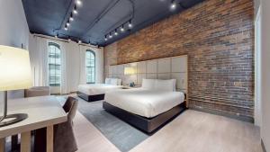 纳什维尔Studio 154 Luxury Hotel的一间卧室设有两张床和砖墙