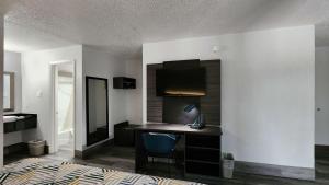 休斯顿Motel 6 Houston, TX - Medical Center - NRG Stadium的一间卧室配有一张桌子和一张床,另一间卧室