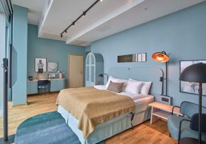 哥德堡Scandic Göteborg Central的一间卧室设有蓝色的墙壁、一张床和一张书桌