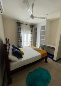 TezoVipingo Nomadic Apartment的一间卧室配有一张带蓝色枕头的大床