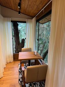 蒙特韦尔迪Estalagem Serra de Minas em Monte Verde的一间带桌椅和大窗户的用餐室