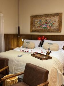 蒙特韦尔迪Estalagem Serra de Minas em Monte Verde的一间卧室配有一张带鲜花的大床