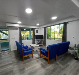 劳托卡Drasa Homestay的客厅配有蓝色椅子和电视