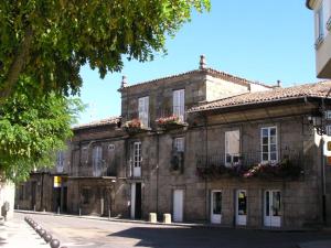 阿波夫拉德特里韦斯Casa Grande De Trives的一座古老的石头建筑,窗户上布满了鲜花