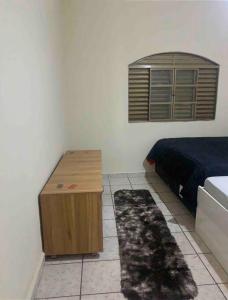 里贝朗普雷托Casa de Férias 1purbana的一间卧室配有一张床和一张木桌