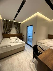 KayacıkAntik Otel的一间卧室配有两张床、一张桌子和一把椅子