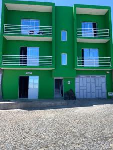 圣菲利佩Casa tchitchi的绿色建筑,设有白色门窗