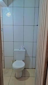 瓜鲁柳斯Casa kitnet的浴室设有白色卫生间,位于瓷砖墙壁上