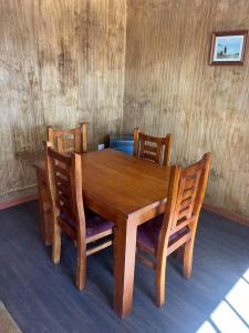 PitrufquénDepartamento en Pitrufquén的木制用餐室配有桌椅和木墙