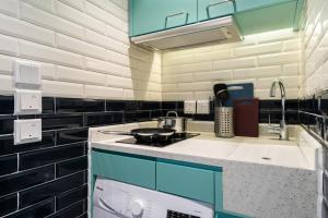香港Habyt Bridges - 64 Staunton Street的厨房配有蓝色橱柜和炉灶烤箱。