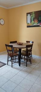 拉日什杜皮库Casa das Pedras Altas的餐桌、椅子和墙上的时钟