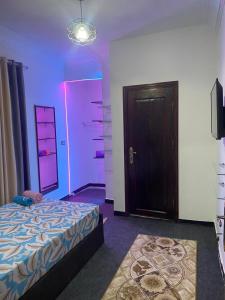 开罗horus desert hotel的一间卧室配有一张床和紫色灯