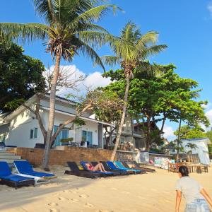 湄南海滩Baanfah Resort Samui的一位女士躺在棕榈树海滩上的沙滩椅上