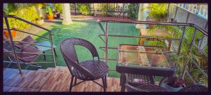 班佩Yawee & Jo Guesthouse的阳台配有两把椅子和一张玻璃桌