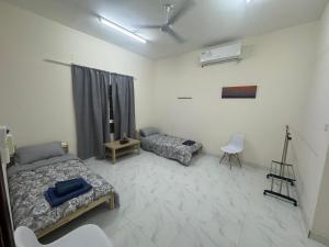 Şūr MaşīrahMaison Masirah的一间带两张床的卧室和一间带摄像机的房间