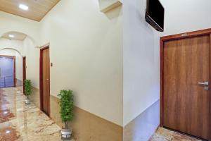 孟买Malali Residency的走廊设有木门,墙上配有电视