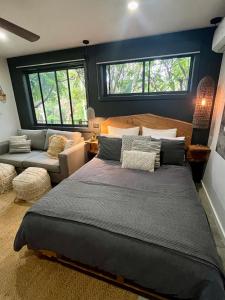麦夸里港Sunnyside Studio - Pet Friendly Luxury Escape的一间卧室配有一张大床和一张沙发