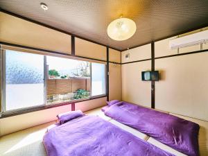 新宫市Kokoyui Guesthouse Shingu的带窗户的客房内的两张床