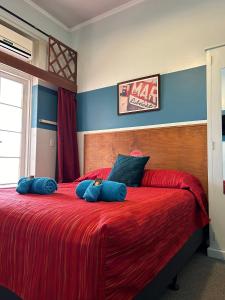 温顿北格雷戈里酒店的一间卧室配有一张带蓝色枕头的大型红色床。