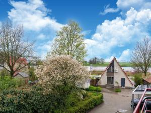 HasseltCozy Holiday Home in Hasselt Near By The Water的树丛和灌木丛的房屋的图象