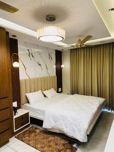焦特布尔MG apartments的卧室配有一张白色大床和吊灯。