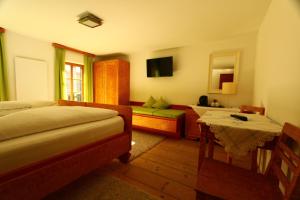 迈尔霍芬施赛布兰德勒旅馆的一间卧室配有两张床、一张桌子和一张沙发