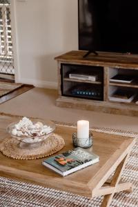 仙女港Banksia Beach House的客厅配有带蜡烛的桌子和电视