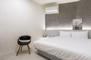 礁溪礁溪亞都溫泉旅店 Newly Renovated的卧室配有白色的床和黑椅
