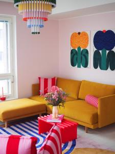 赫尔辛基Candy-Colored Two-Room Condo with Sweet views的客厅配有两张黄色的沙发和一张桌子
