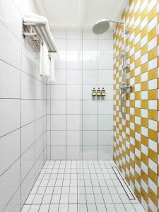 琅勃拉邦Senglao Boutique Hotel Luang Prabang的浴室设有黄色和白色瓷砖淋浴。