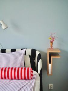 赫尔辛基Candy-Colored Two-Room Condo with Sweet views的一间卧室,配有一张床,书架上放着花瓶