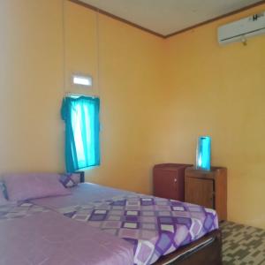 比哈尔Karang Besi Losmen的一间卧室设有一张床和一个窗口