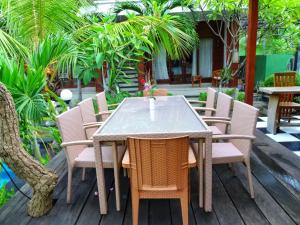 蓝梦岛Villa Cempaka Lembongan的棕榈树庭院内的桌椅