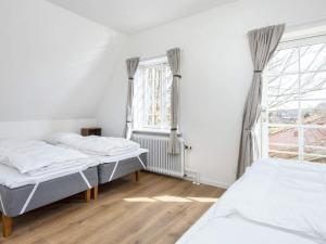 哈泽斯莱乌Holiday home Haderslev LVII的一间卧室设有两张床和窗户。