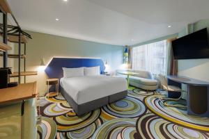 悉尼Adge Hotel and Residence - Adge King - Australia的酒店客房,配有床和电视