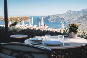 德阿萨佩德利萨酒店的一张桌子,上面摆放着盘子和玻璃杯,享有海景