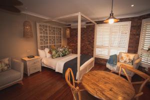 巴利纳波丽娜棕榈精品汽车旅馆的卧室配有一张床和一张桌子及椅子