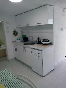 诺弗多伊兰Apartmant Lidija的厨房配有白色橱柜、水槽和柜台。