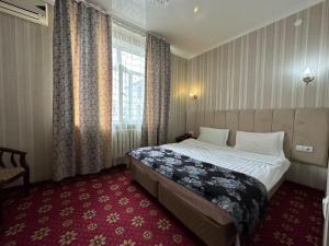 奇姆肯特ОРДА的酒店客房设有床和窗户。