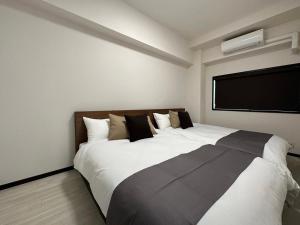 HijiyamachōLuxes - 2Br Apt for 10ppl Very Good Location的一间配有电视的客房内的一张大白色床