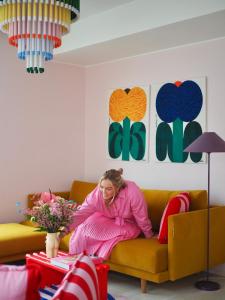 赫尔辛基Candy-Colored Two-Room Condo with Sweet views的坐在客厅沙发上的女人