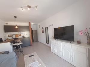 科斯塔德安提瓜Apartamento London Complex Amaya Fuerteventura的客厅配有大屏幕平面电视