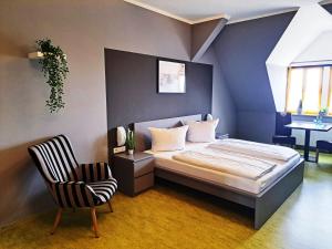 巴特迪伦贝格Hotel Altes Salzamt的一间卧室配有一张床和一把椅子