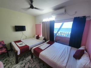SingānallūrParadise Harmony Beach Resort的酒店客房设有两张床和窗户。
