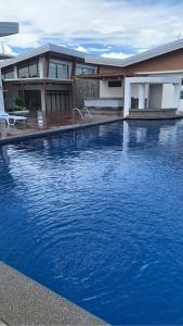 General TriasCamilyn Home Stay的一座大蓝色游泳池,位于房子前