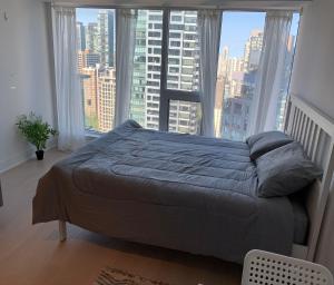 多伦多Toronto Premier INN的卧室内的一张床铺,设有大窗户