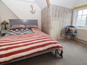 巴德利索尔特顿Stone's Throw的一间卧室配有悬挂美国国旗的床和蓝椅