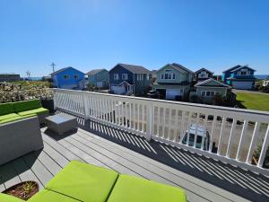 太平洋海滩Sunkissed - Clear Pricing -- Walk to Beach, Ocean Views, Firepit, Privacy Fence, Gardens的一个带绿色椅子的甲板和房子
