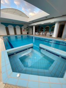 沃洛斯卡洛尼酒店的蓝色瓷砖酒店的大型游泳池